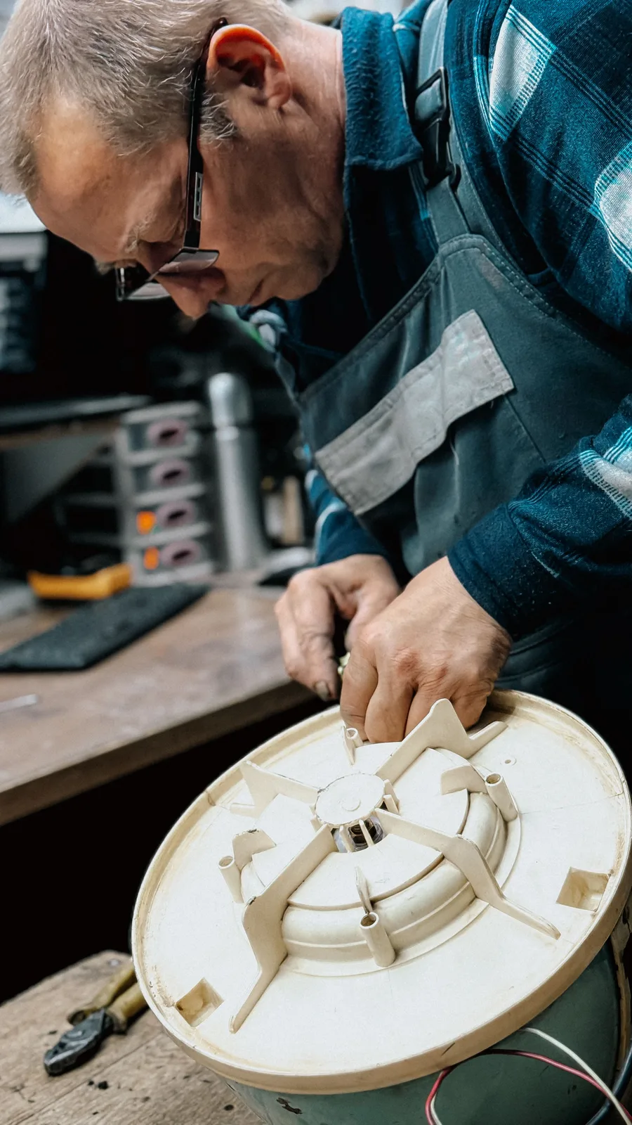 A technician inspecting a mechanical component at a workbench