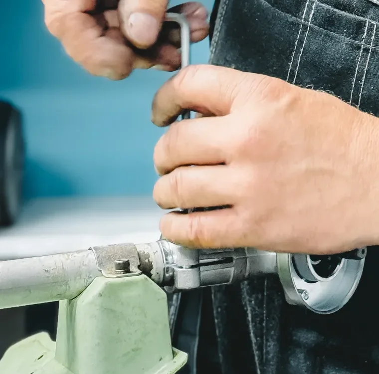 Close-up of hands using a tool to work on a pipe connection